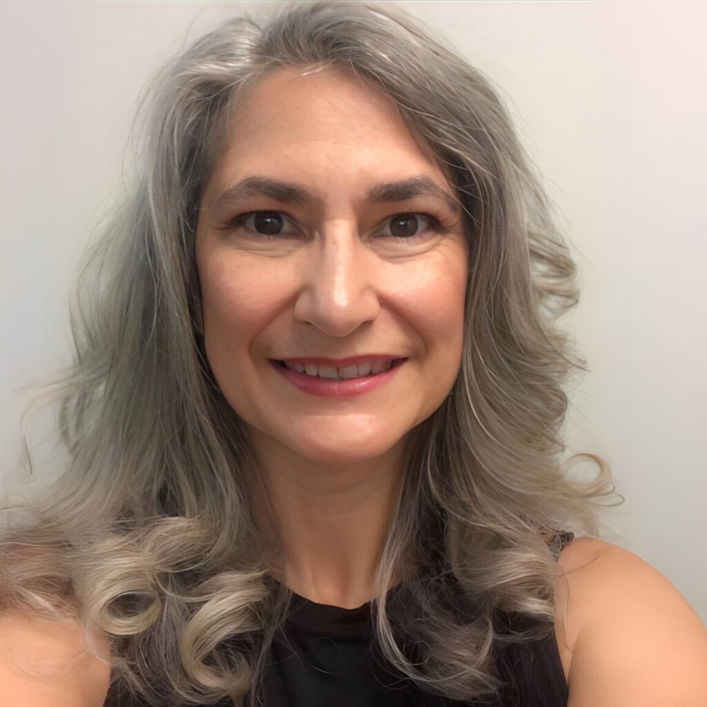 Woman with wavy silver hair, smiling